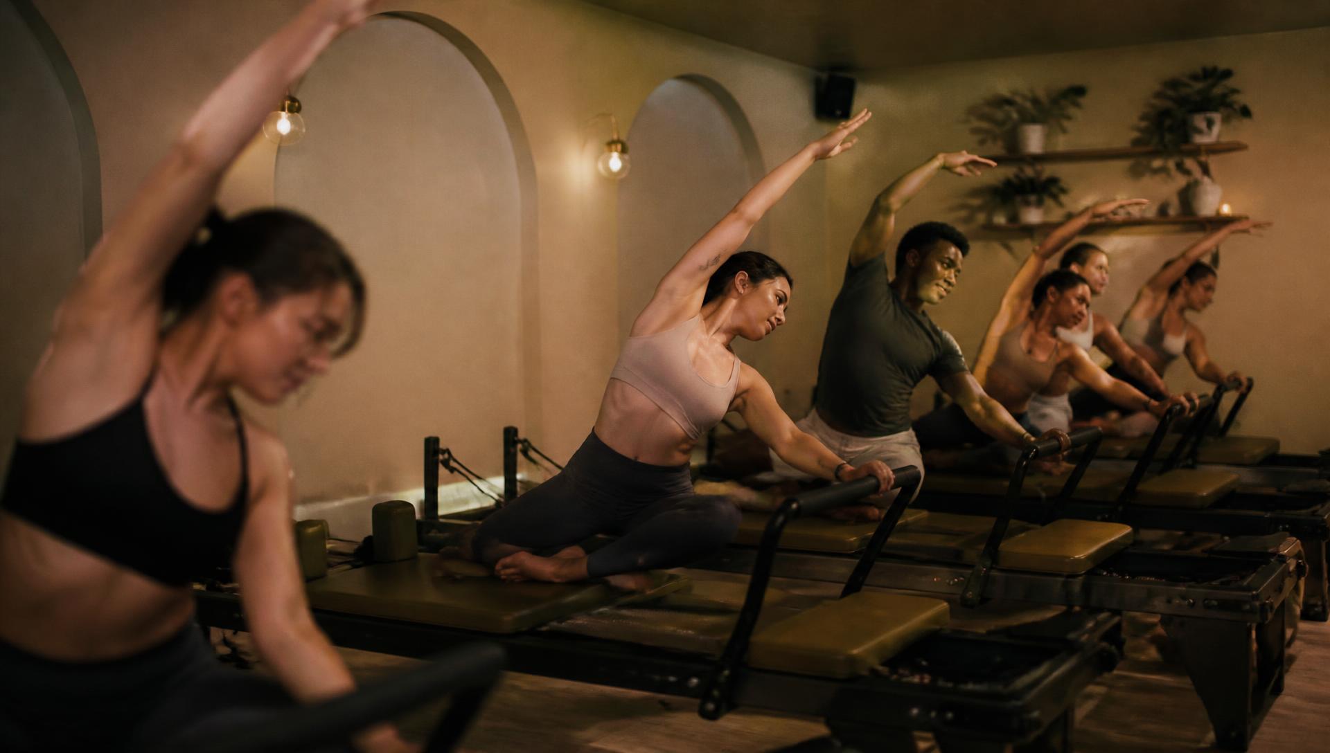 A small reformer pilates class of six people moving together