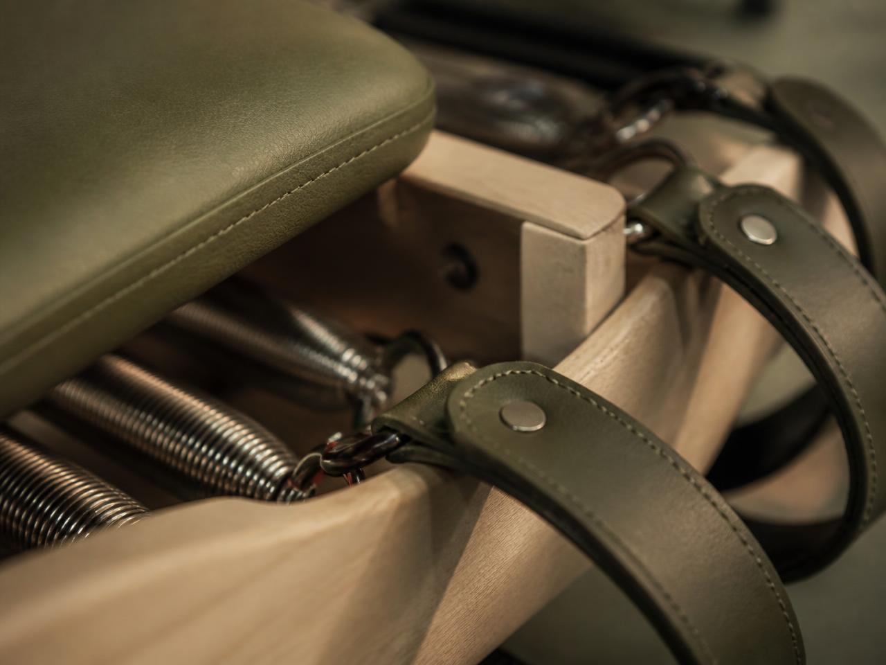 Close detail of a reformer's leather straps and springs